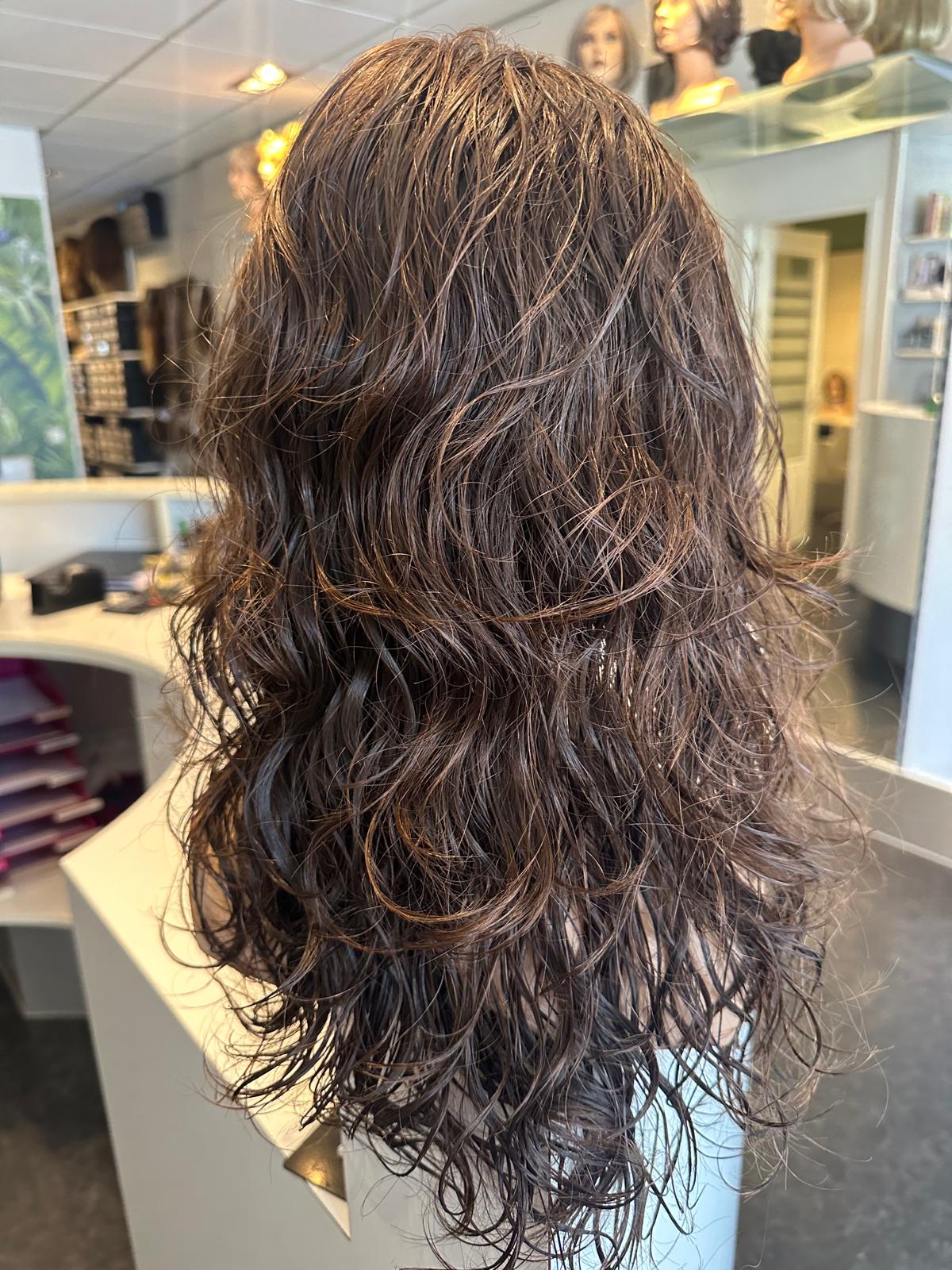 Haarwerk met natuurlijke krullen van echt haar met zachte natuurlijke valling